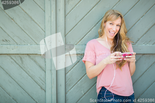 Image of Outdoor Portrait of Young Adult Brown Eyed Woman Listening To Mu