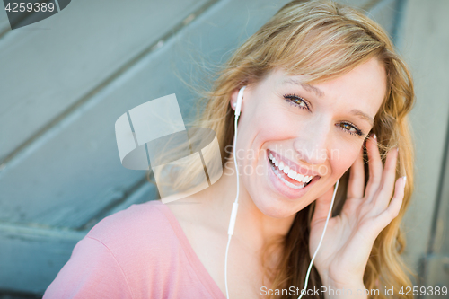 Image of Outdoor Portrait of Young Adult Brown Eyed Woman Listening To Mu