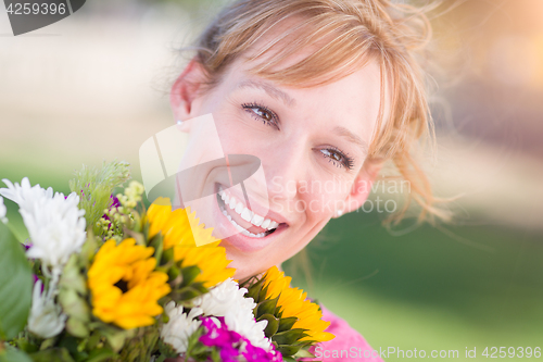 Image of Outdoor Portrait of an Excited Young Adult Brown Eyed Woman Hold