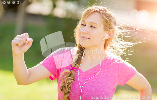 Image of Young Fit Adult Woman Outdoors During Workout Listening To Music
