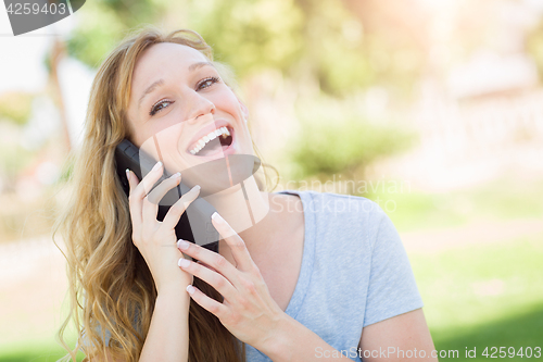 Image of Young Adult Woman Outdoors Talking on Her Smart Phone.