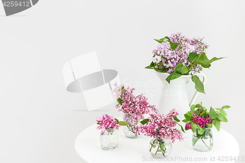 Image of Vases with blooming spring flowers on a round table