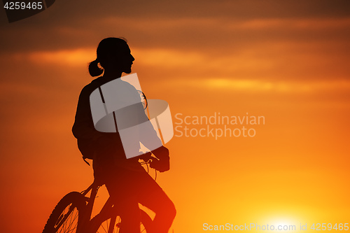 Image of Silhouette of a bike on sky background during sunset