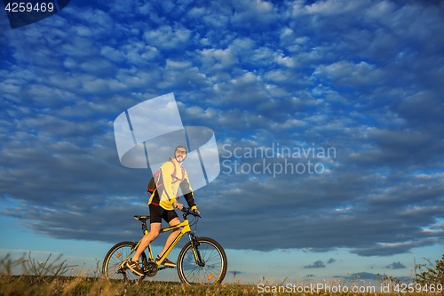 Image of Young man cycling on a rural road