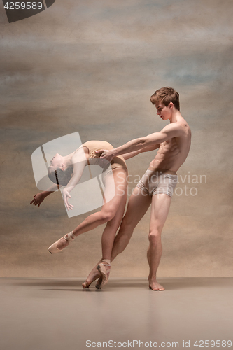 Image of Couple of ballet dancers posing over gray background