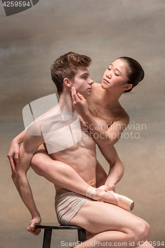 Image of Couple of ballet dancers posing over gray background