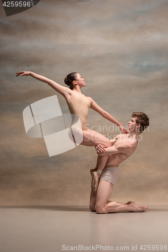 Image of Couple of ballet dancers posing over gray background