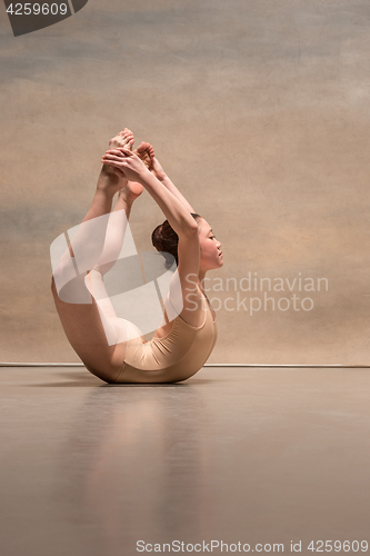 Image of The female ballet dancer posing over gray background