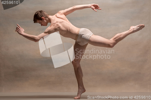 Image of The male ballet dancer posing over gray background