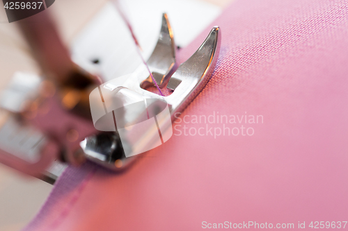 Image of sewing machine presser foot stitching fabric