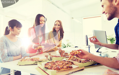 Image of happy business team eating pizza in office