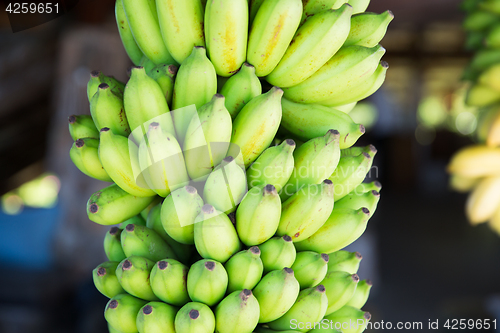 Image of bunch of green bananas at street market