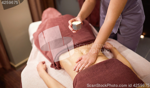 Image of woman lying and having massage with hot oil at spa
