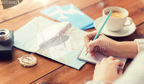 Image of close up of traveler hands with notepad and pencil