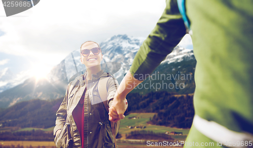 Image of happy couple with backpacks hiking outdoors