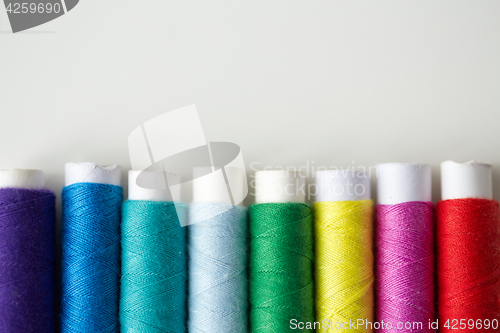 Image of row of colorful thread spools on table