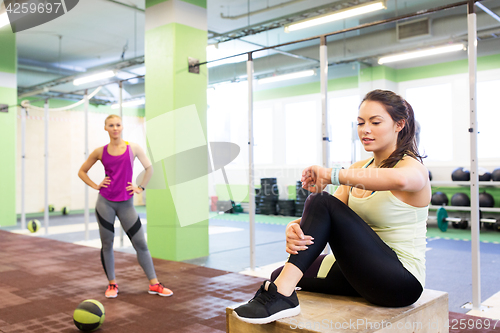 Image of women with fitness tracker and ball in gym