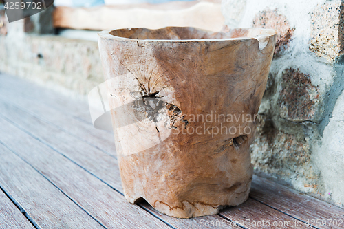 Image of outdoor wooden bowl or vase on terrace floor