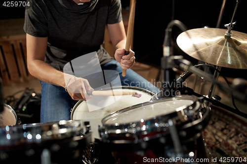 Image of male musician playing drums and cymbals at concert