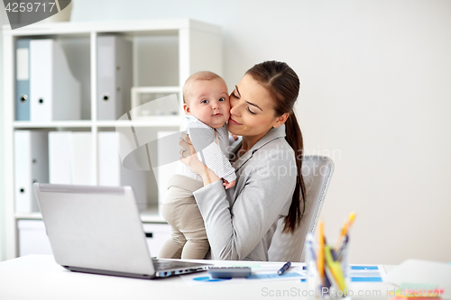 Image of happy businesswoman with baby and laptop at office