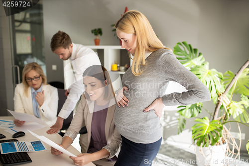 Image of happy business team with papers in office
