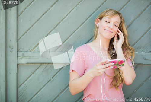 Image of Outdoor Portrait of Young Adult Brown Eyed Woman Listening To Mu