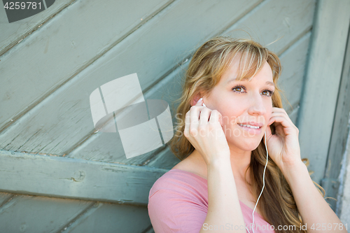 Image of Outdoor Portrait of Young Adult Brown Eyed Woman Listening To Mu