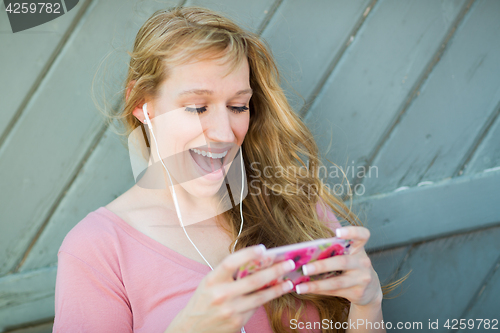 Image of Outdoor Portrait of Young Adult Brown Eyed Woman Listening To Mu