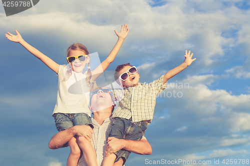 Image of Father and children playing in the park  at the day time.