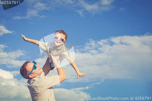 Image of Father and son playing in the park  at the day time.