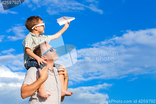 Image of Father and son playing in the park  at the day time.