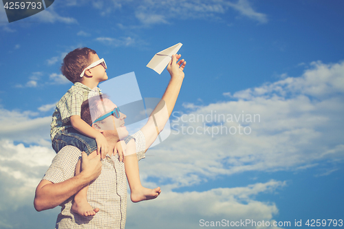 Image of Father and son playing in the park  at the day time.