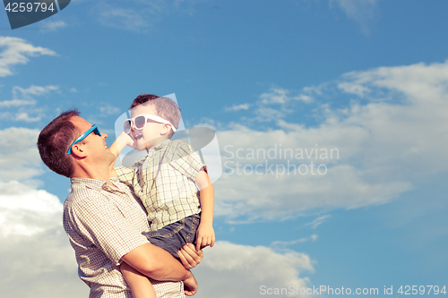 Image of Father and son playing in the park  at the day time.