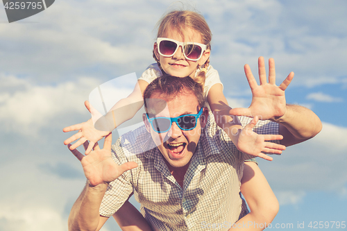 Image of Father and daughter playing in the park  at the day time.