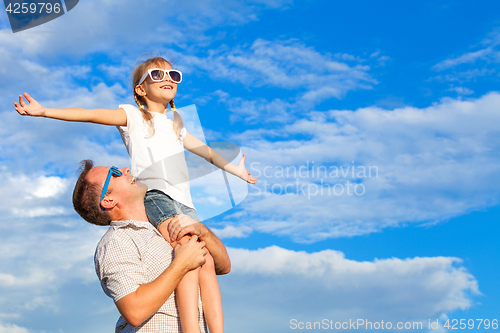 Image of Father and daughter playing in the park  at the day time.