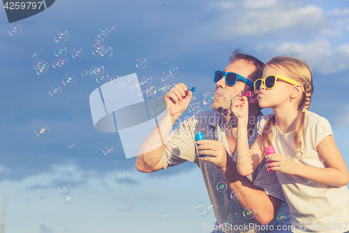 Image of Father and daughter playing in the park  at the day time.