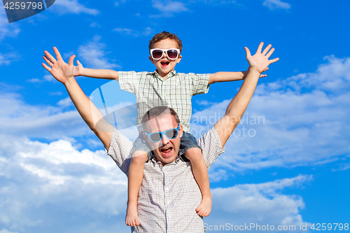 Image of Father and son playing in the park  at the day time.