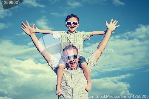 Image of Father and son playing in the park  at the day time.