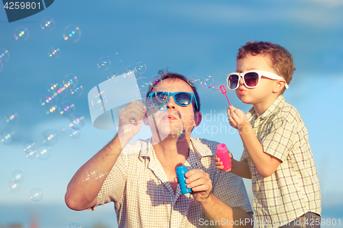 Image of Father and son playing in the park  at the day time.