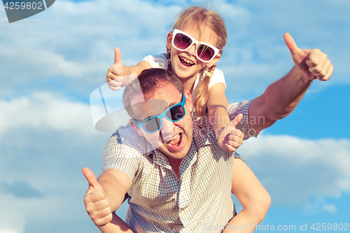 Image of Father and daughter playing in the park  at the day time.