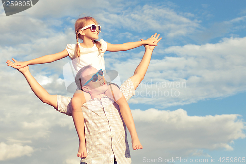 Image of Father and daughter playing in the park  at the day time.