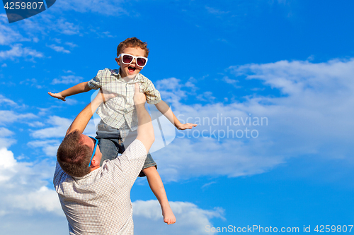 Image of Father and son playing in the park  at the day time.