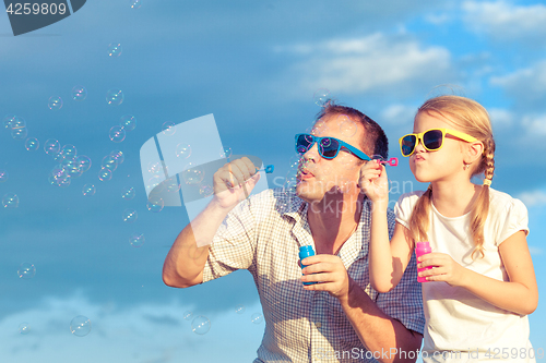 Image of Father and daughter playing in the park  at the day time.