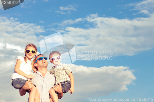 Image of Father and children playing in the park  at the day time.