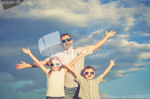 Image of Father and children playing in the park  at the day time.