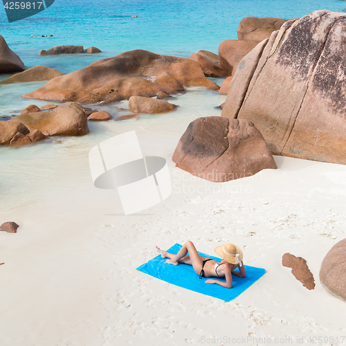 Image of Woman sunbathing at Anse Lazio picture perfect beach on Praslin Island, Seychelles.