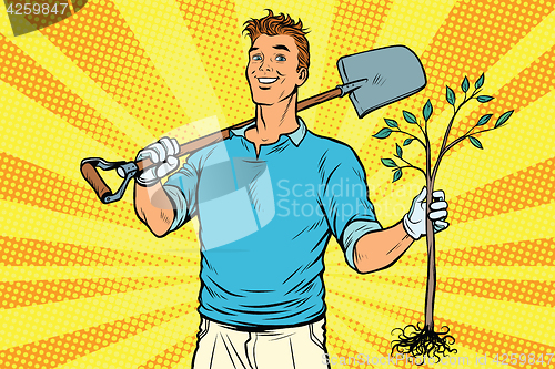 Image of Man gardener with a shovel and sapling