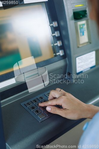 Image of Woman entering pin-code in ATM