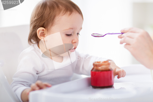 Image of mother feeding baby with puree at home