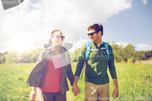 Image of happy couple with backpacks hiking outdoors